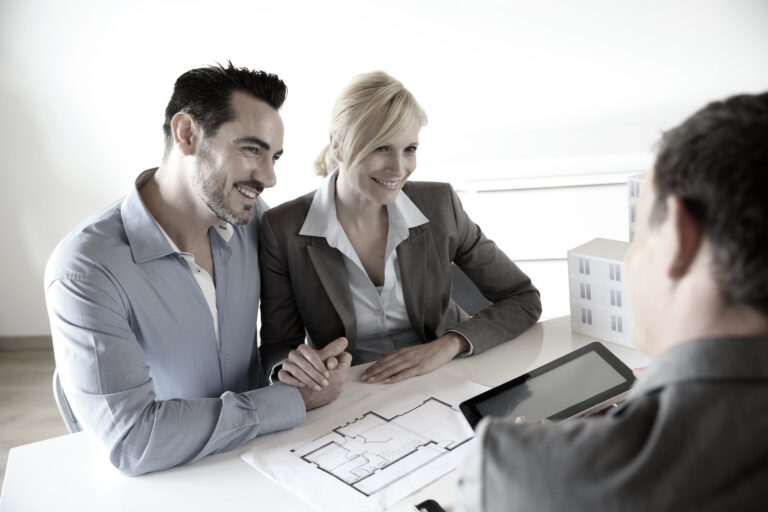 agent reviewing floor plan with buyers